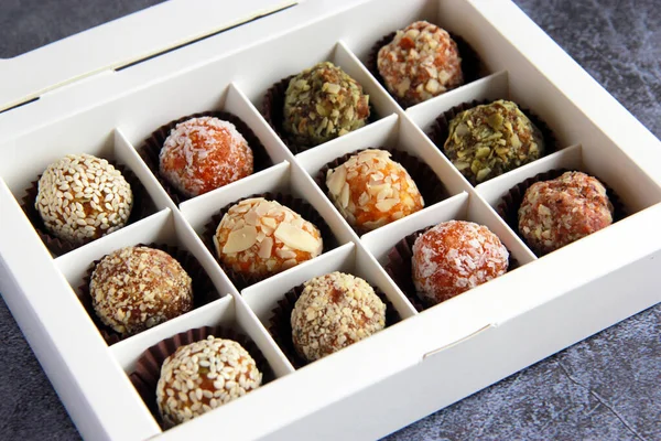 Homemade natural vegan sweets without sugar. Delicious sweets made of dry fruits and nuts in the box.