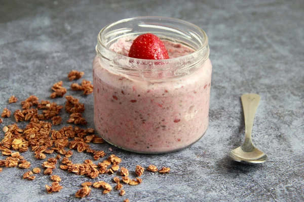 一个通宵的燕麦与草莓和椰奶 盛有浆果和植物牛奶的罐子里的燕麦粥 图库图片