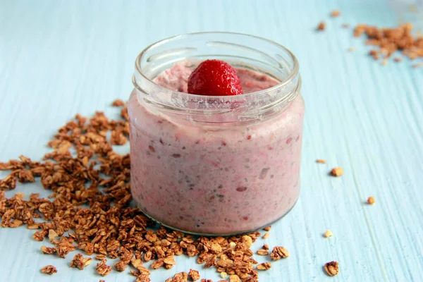 一个通宵的燕麦与草莓和椰奶 盛有浆果和植物牛奶的罐子里的燕麦粥 图库照片