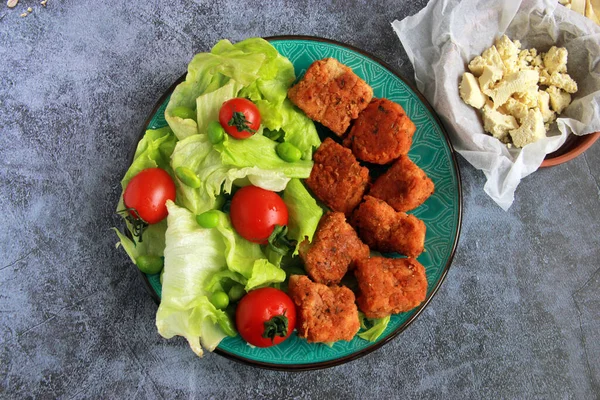 在盘子里放上新鲜蔬菜和沙拉叶的豆腐块 开胃菜 健康食品 免版税图库照片