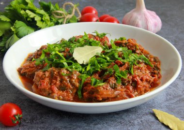 Geleneksel tavuk chakhokhbili tabakta. Gürcistan usulü haşlanmış tavuk, domates sosu ve taze otlar..