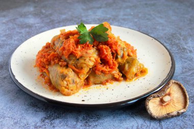 Vegetarian cabbage rolls with mushroom and rice filling. Traditional ukrainian holubtsi without meat. Lent dish for Christmas - holubtsi with dry mushrooms and carrot sauce. clipart