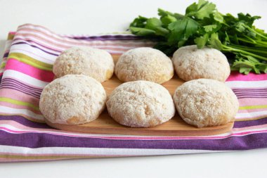 Kesme tahtasında çiğ tavuk pirzolası. Dereotlu el yapımı kıymalı tavuk köftesi. Tavuk pirzolası pişirmeye hazırım..