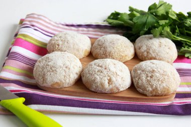 Kesme tahtasında çiğ tavuk pirzolası. Dereotlu el yapımı kıymalı tavuk köftesi. Tavuk pirzolası pişirmeye hazırım..