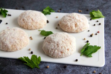 Kesme tahtasında çiğ tavuk pirzolası. Dereotlu el yapımı kıymalı tavuk köftesi. Tavuk pirzolası pişirmeye hazırım..