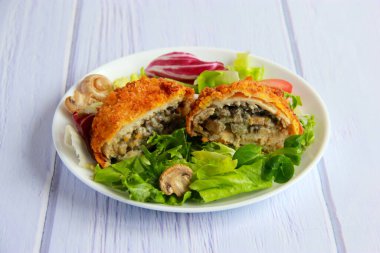 Mantarlı ve peynirli tavuk pirzolası. Mantarlı tavuk pirzolası ve tabakta sebze salatası..