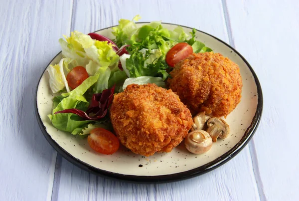 Mantarlı ve peynirli tavuk pirzolası. Mantarlı tavuk pirzolası ve tabakta sebze salatası..