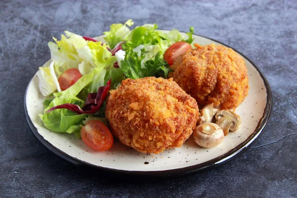 Mantarlı ve peynirli tavuk pirzolası. Mantarlı tavuk pirzolası ve tabakta sebze salatası..