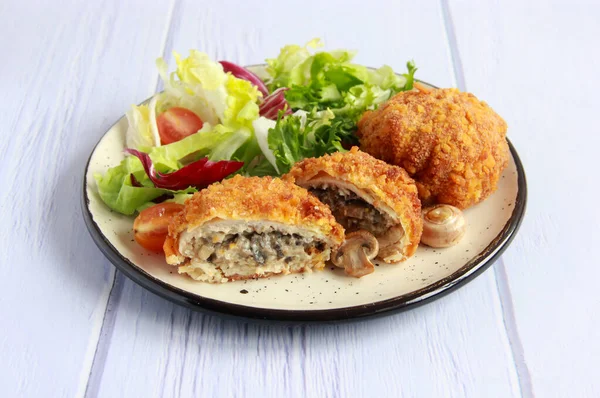 Mantarlı ve peynirli tavuk pirzolası. Mantarlı tavuk pirzolası ve tabakta sebze salatası..