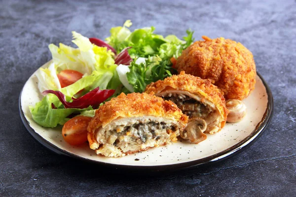 Mantarlı ve peynirli tavuk pirzolası. Mantarlı tavuk pirzolası ve tabakta sebze salatası..