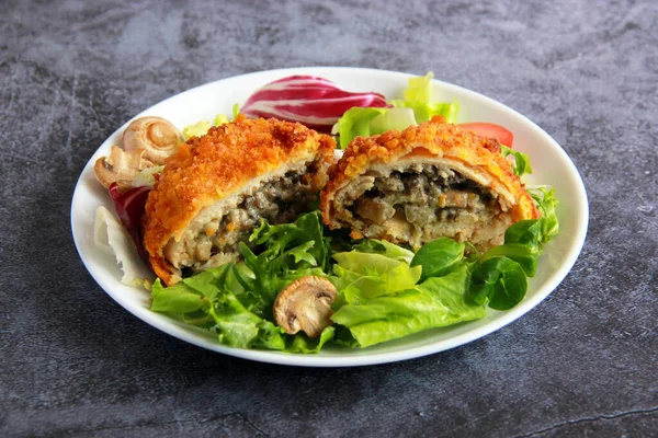 Mantarlı ve peynirli tavuk pirzolası. Mantarlı tavuk pirzolası ve tabakta sebze salatası..