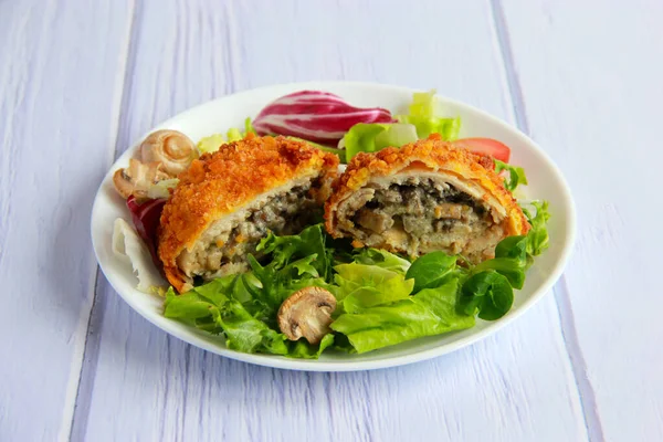 Mantarlı ve peynirli tavuk pirzolası. Mantarlı tavuk pirzolası ve tabakta sebze salatası..