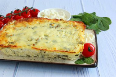 Ev yapımı peynir, süzme peynir, mozzarella ve ıspanak. Tabakta tam peynirli güveç, ıspanak yaprağı, domates ve feta..