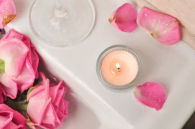 Bir bardak şarap ve bir buket pembe gül lavaboda