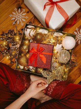 Ağaç ve ev için Altın Noel süslerini tutan kadınlar.