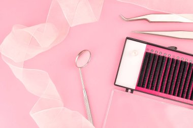 Pembe arka planda kirpik takviyesi için ekipman. Yüksek kalite fotoğraf