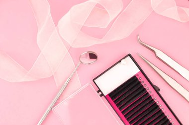 Pembe arka planda kirpik takviyesi için ekipman. Yüksek kalite fotoğraf