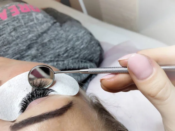 Lash extensions in beauty salon macro eye . High quality photo