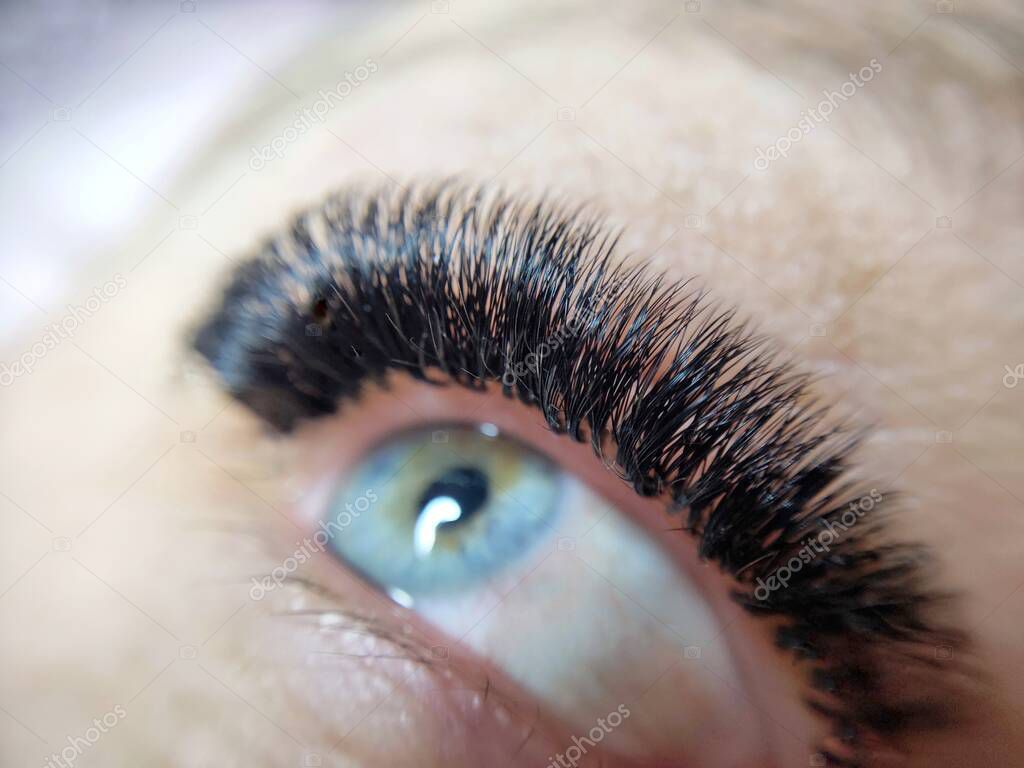 Lash extensions in beauty salon macro eye . High quality photo