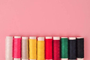 Pembe arka planda dikmek için çok renkli iplikler. Yüksek kalite fotoğraf