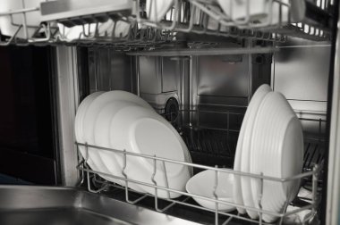 Mutfakta beyaz tabaklar ve fincanlar olan bulaşık makinesi. Yüksek kalite fotoğraf