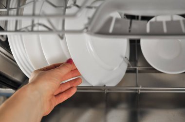 Mutfakta beyaz tabaklar ve fincanlar olan bulaşık makinesi. Yüksek kalite fotoğraf