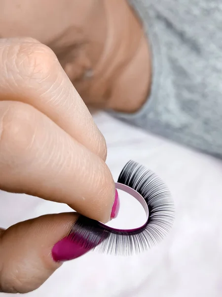 Streifen Mit Schwarzen Falschen Wimpern Der Hand Mit Rosa Maniküre — Stockfoto