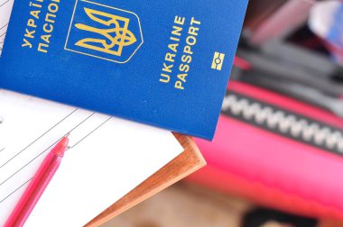Belge imzalamak için kırmızı kalem ve Ukrayna uluslararası pasaportu.
