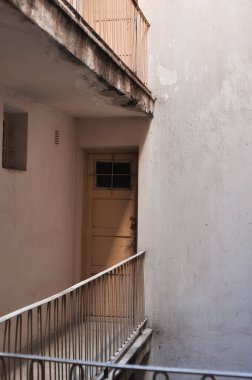 İçerisi parmaklıklı, kapısı olan eski boş bir bina. 