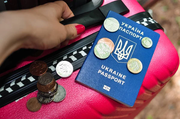 Ukrainian international passport pences and pink travel bag of refugee — стокове фото