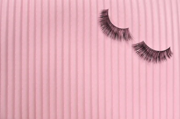 Fake lashes on pink background copy space. High quality photo