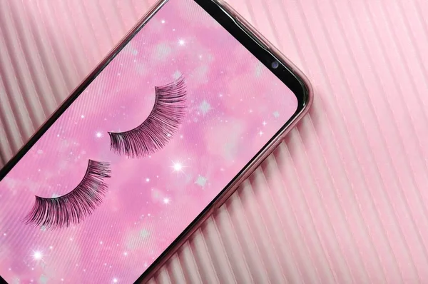 Fake lashes on pink background copy space. High quality photo