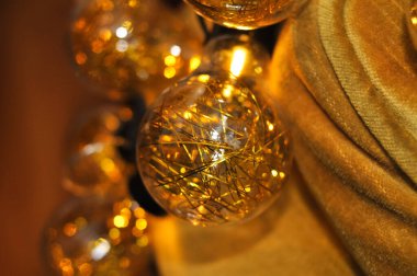 Koltuğunda ışıklar olan altın bir Noel çelengi. Tatiller için dekorasyon.