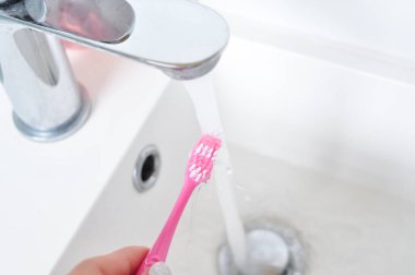 Günlük temizlik için pembe diş fırçası, sabah rutini, banyo aksesuarları.