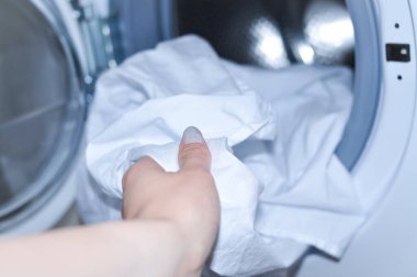 Çamaşır makinesindeki beyaz temiz çarşafları kapatın...