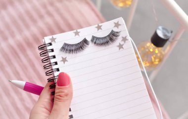 Güzellik salonunda kirpik uzantıları için randevu almak için defter ve kalem. Yüksek kalite fotoğraf
