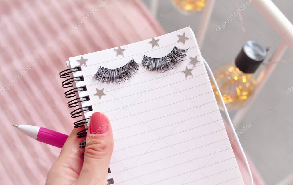 Notebook and a pen for making appointment on eyelash extensions in beauty salon. High quality photo