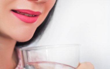 Close up of young woman drinking glass of pure still water. High quality photo