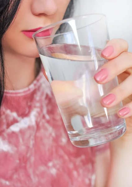 Close up of young woman drinking glass of pure still water. High quality photo