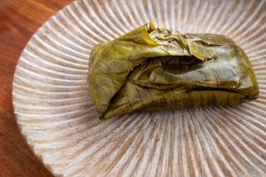 Meksika, Oaxaca 'da Tamale yemek. Tamal masası, muz yaprağına sarılmış tavuk ve köstebek zencisi dolu..