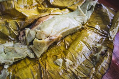 Meksika, Oaxaca 'da Tamale yemek. Tamal masası, muz yaprağına sarılmış tavuk ve köstebek zencisi dolu..