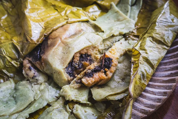 メキシコのオアハカでタマレスを食べる タマルはマサでモグラと鶏がバナナの葉に包まれています — ストック写真