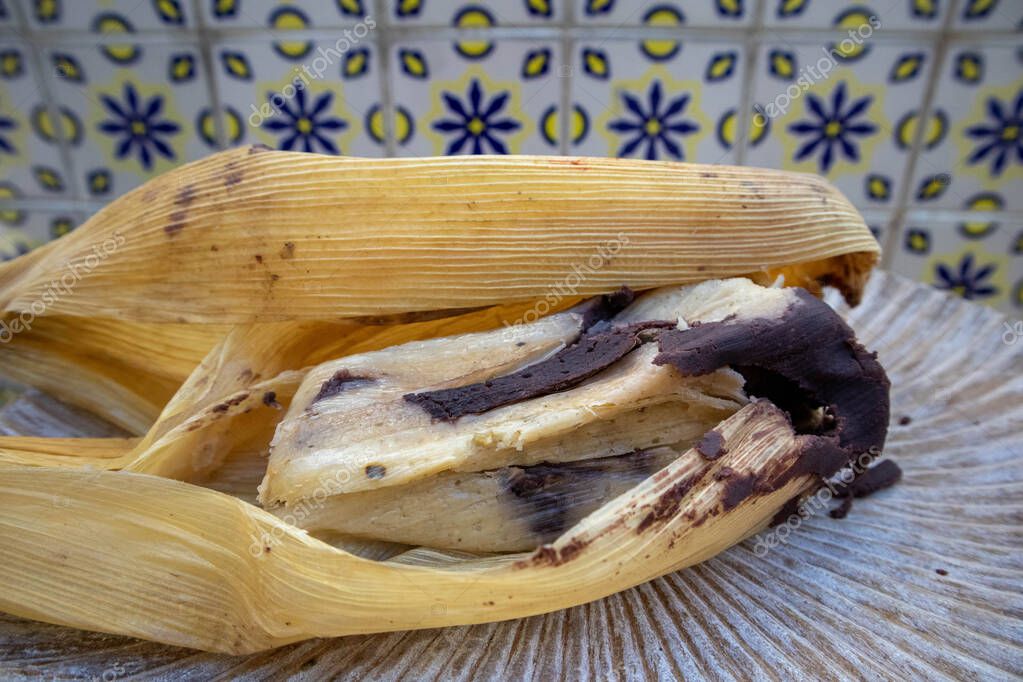 Comer tamales en Oaxaca, México. El tamal es masa llena de mole negro y