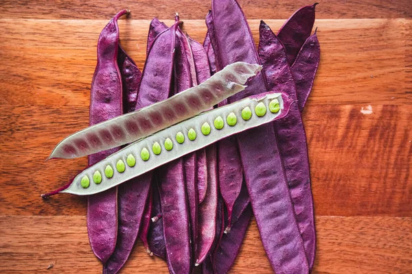 Oaxaca Meksika 'da bir tahta masaya mor Guaje tohumları yığını. İçinde tohumlar olan açık bir kapsül var..