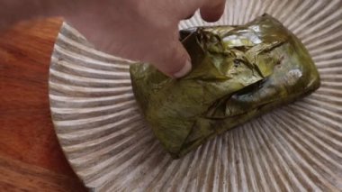 Muz yaprağına sarılı bir Oaxacan Tamale 'sinin paketini açıyorum..