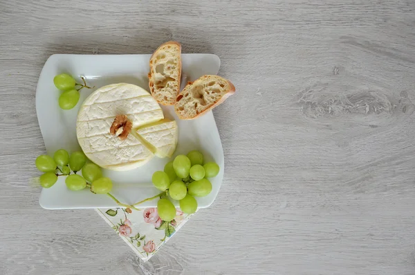 Goat cheese and grapes on the plate — Stock Photo, Image