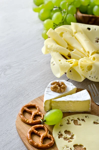 Cut cheese with grapes and nuts copyspace — Stock Photo, Image