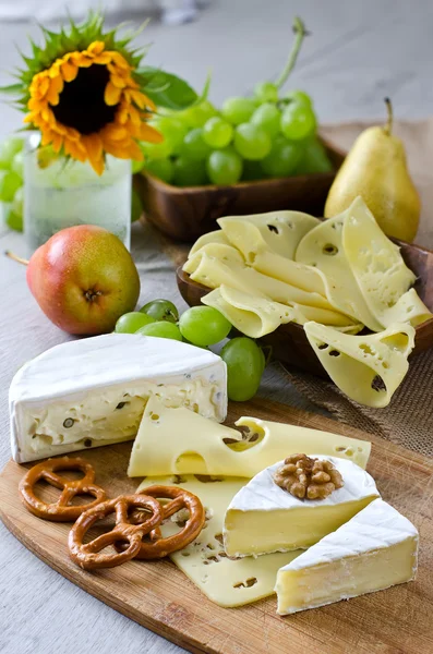 Different types of cheese with fruits and nuts — Stock Photo, Image