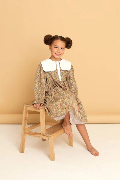Ritratto Studio Una Graziosa Bambina Soffice Vestito Beige Acconciatura Insolita — Foto Stock