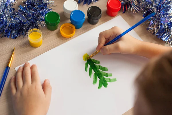 A students desk with drawing tools and a notebook, paints, brushes for drawing a Christmas tree and a snowman. Child development. — Fotografia de Stock